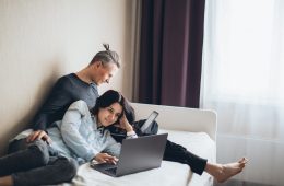 couple sitting on the bed working